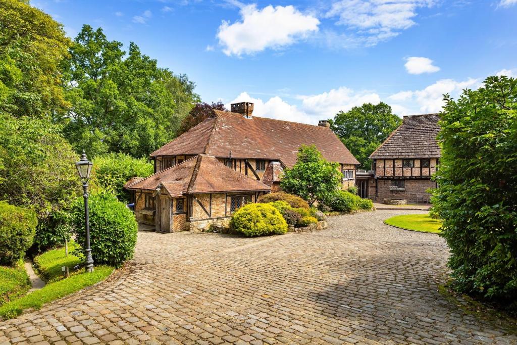 a large house with a brick driveway in front of it at Finest Retreats - Sandhill Cottage with hot tub in Turners Hill