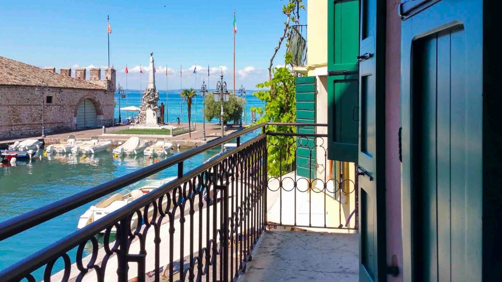 a balcony of a building with a view of the water at Porto Vecchio Appartamenti in Lazise