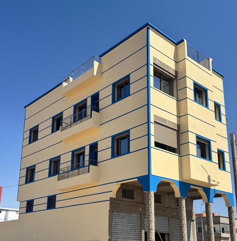 a building with columns in front of a blue sky at Houssam immobilier 7 in Souira Guedima