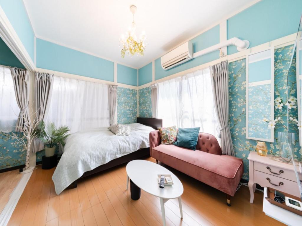 a bedroom with a bed and a couch and a table at Shinjuku, 3min walk from Nishi-Shinjuku 5-chome Sta, 3min Shinjuku Sta Switch, Wi-Fi ,Pocketwi-Fi in Tokyo