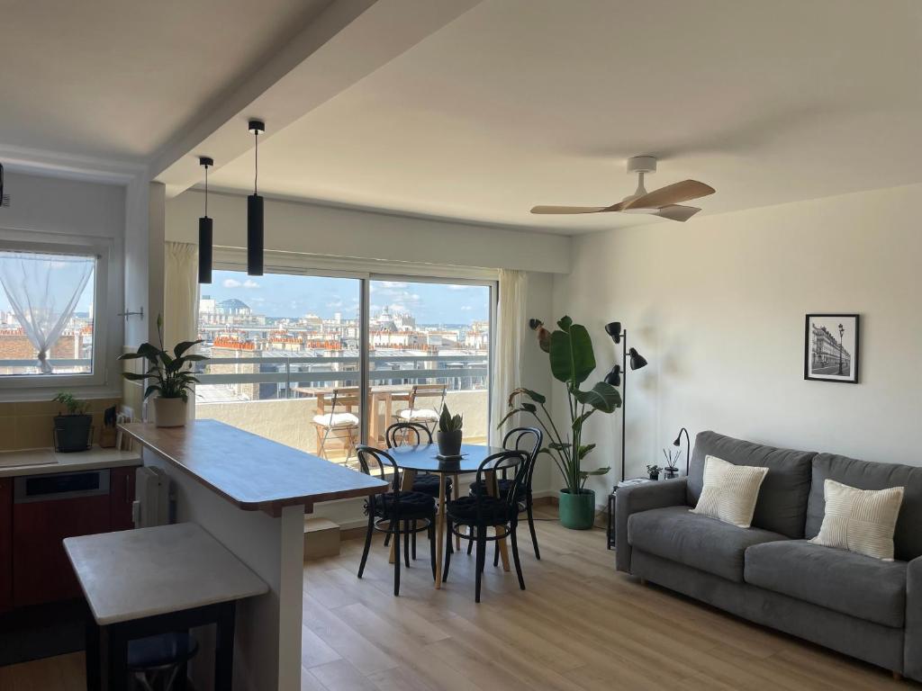 une cuisine et un salon avec une table et un canapé dans l'établissement Home F8 - Terrace Paris's view, Eiffel Tower area, à Paris