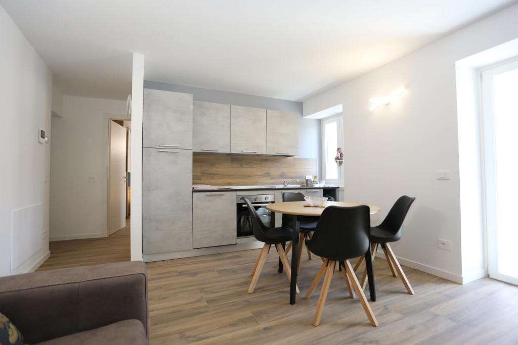 Casa BEA 2 في كاستوني ديلا بريسولانا: مطبخ وغرفة طعام مع طاولة وكراسي