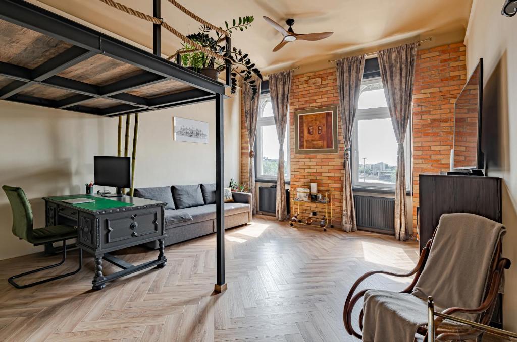 a room with a desk and a bed and a couch at Rustic Gallery Apartment with Panoramic View and AC in Budapest