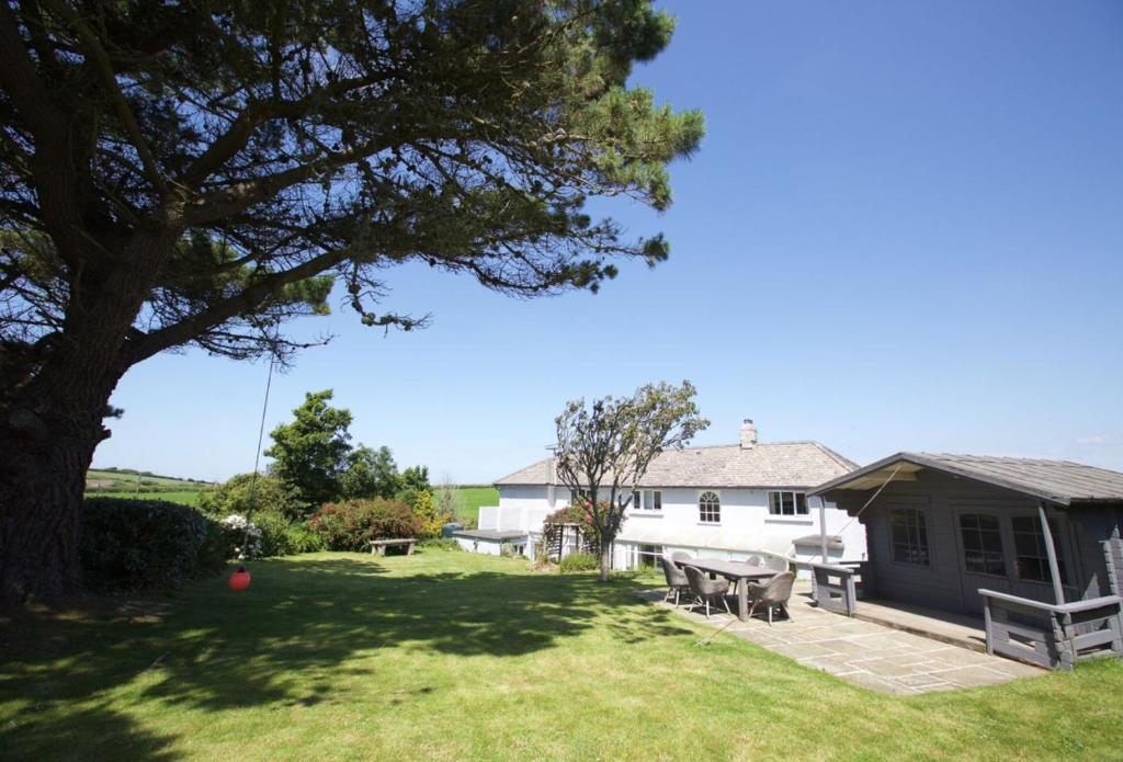 a house with a table and chairs in the yard at Penrose Cottage in Bude