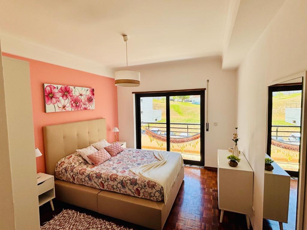 a bedroom with a bed with pink walls at Azul sea’s view flat (3bedrooms), 3 terraces/wifi in Buarcos