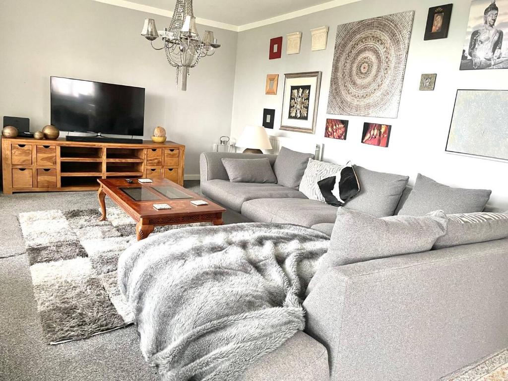 a living room with a couch and a tv at Spacious, smart apartment near City Centre and Coop Arena Free parking in Manchester