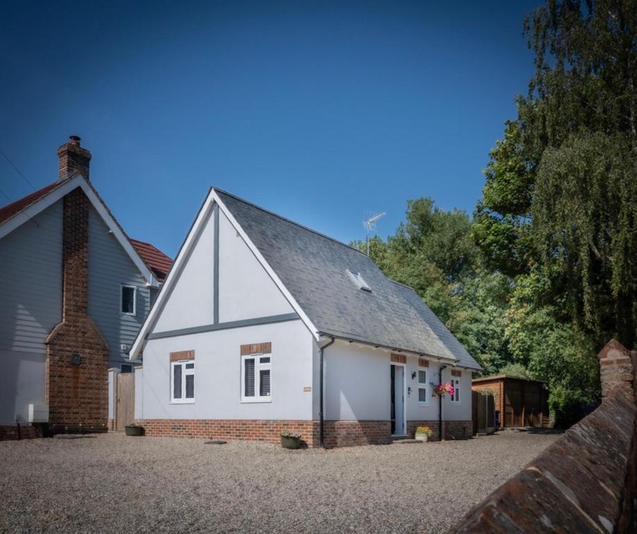 a white house with a brick at Hedgehog Cottage in Bury Saint Edmunds
