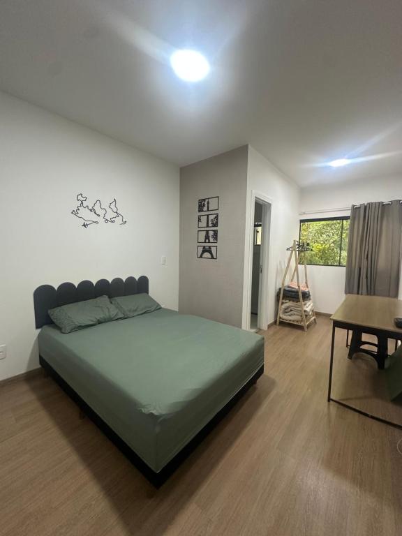 a bedroom with a bed and a table and a desk at Sobrado moderno in Blumenau