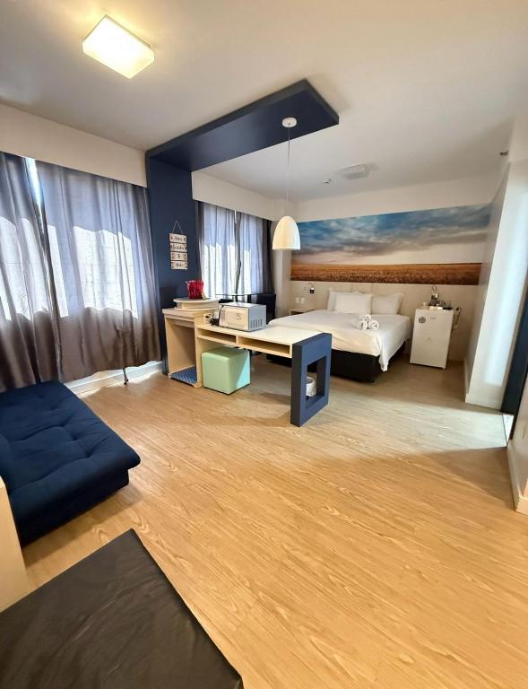 a hotel room with a bed and a couch at Flat em Alphaville in Barueri