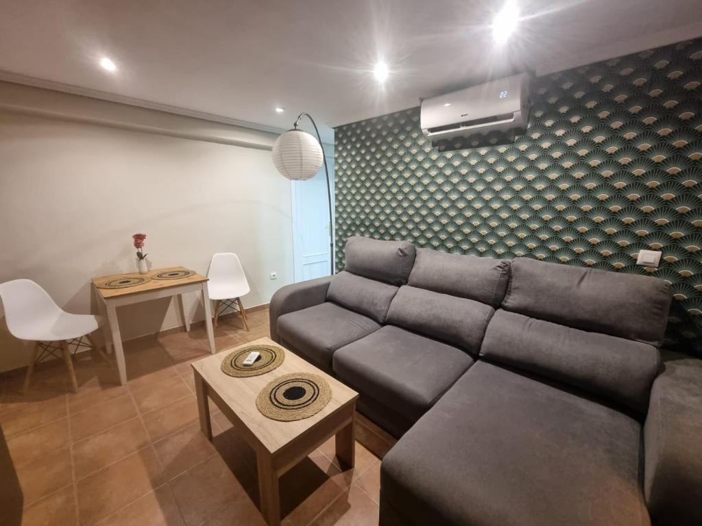 ein Wohnzimmer mit Sofa und Tisch in der Unterkunft Alojamiento con vistas al mar en Puerto Sagunto in Puerto de Sagunto