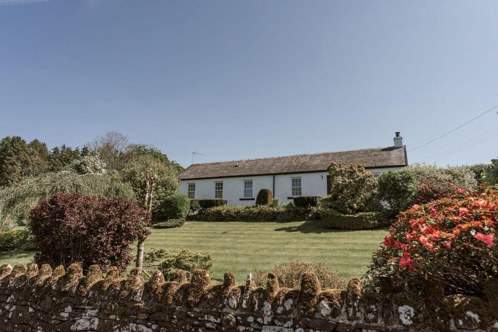 a house with a fence in front of a yard at Rosebank Cottage - Hot Tub & Log Stove in Alexandria