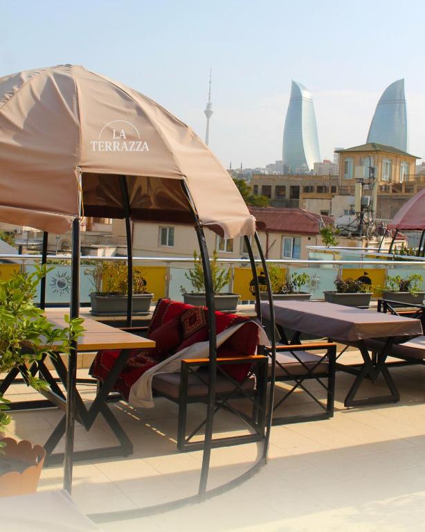 a table and chairs under an umbrella on a roof at Atropat Old City Hotel in Baku