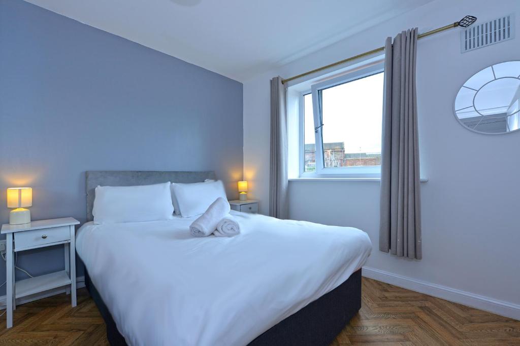 a bedroom with a large bed and a window at Broad Gauge Apartments in Wolverhampton