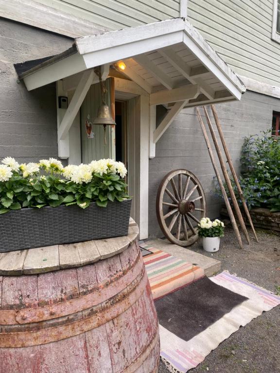 a house with an awning and a wooden wheel with flowers at Villa Puistolan huone in Hämeenlinna