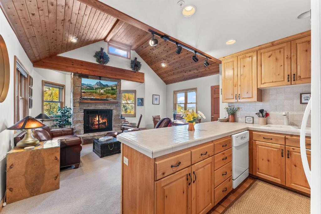 a kitchen with wooden cabinets and a fireplace at Cozy Hillside Cottage Overlooking Main Street in Park City