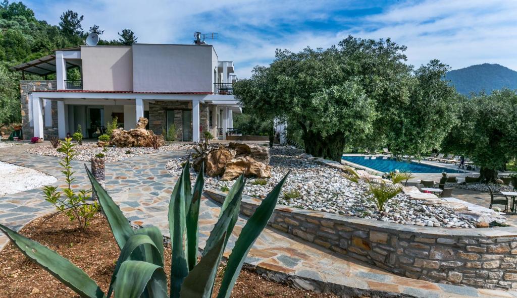 a villa with a swimming pool and a house at Ipsario Garden Hotel in Skala Potamias