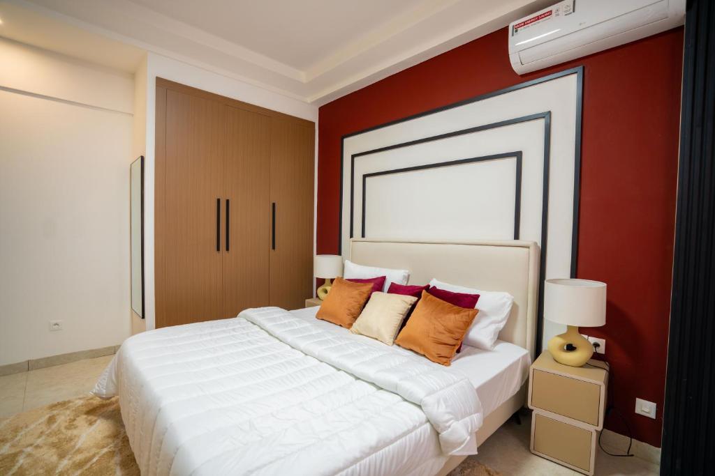 una camera da letto con un grande letto bianco con pareti rosse di Teranga Baobab a Dakar