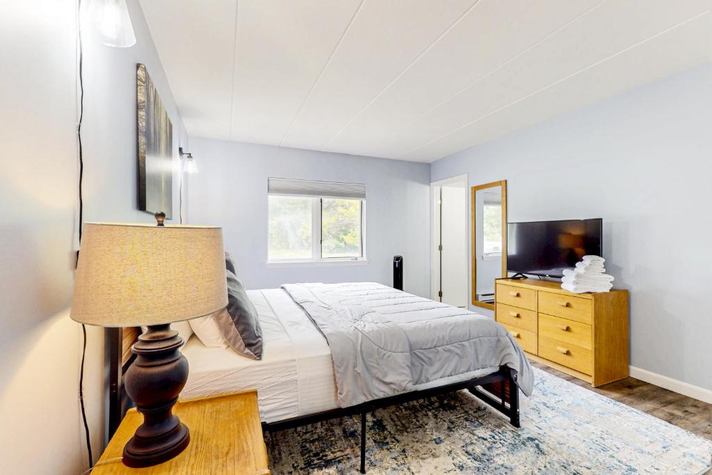a bedroom with a bed with a lamp and a television at 5B Mountain Village- Unit B in Dover