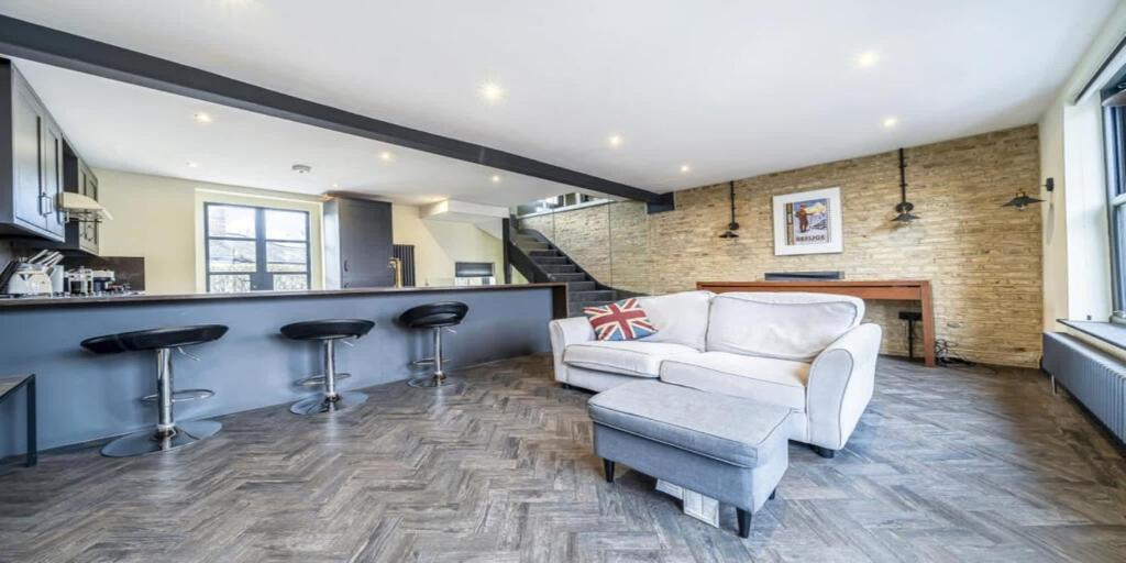 a living room with a white couch and a bar at Elegant 2 Bedroom Apartment in Bromley