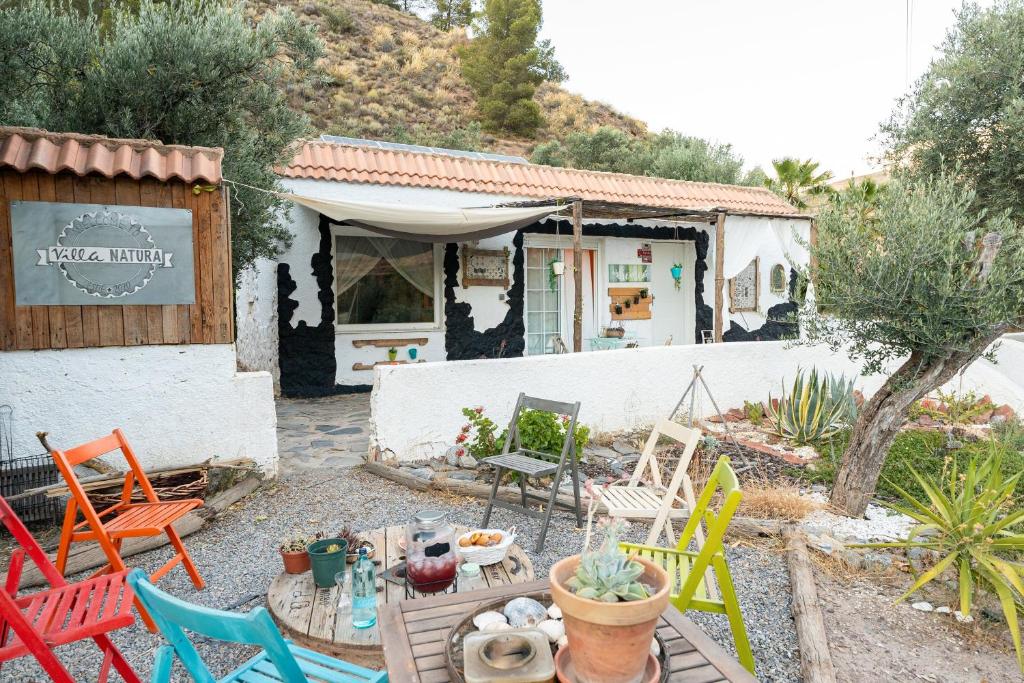 un gruppo di sedie e un tavolo davanti a una casa di Villa Natura Paradise a Alcolea