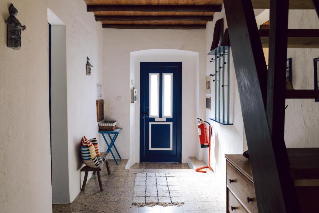 a hallway with a blue door in a room at Jardim de Vénus in Vila de Frades