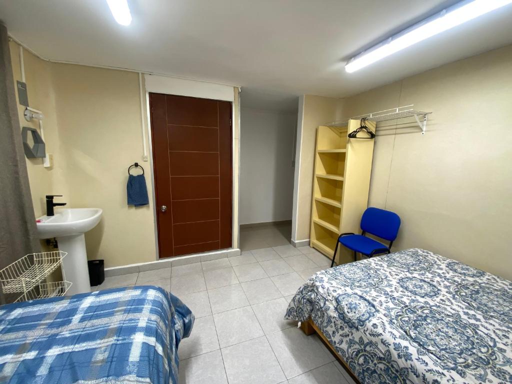 a bedroom with a bed and a sink and a bathroom at Hostal TO3 in Ciudad Madero