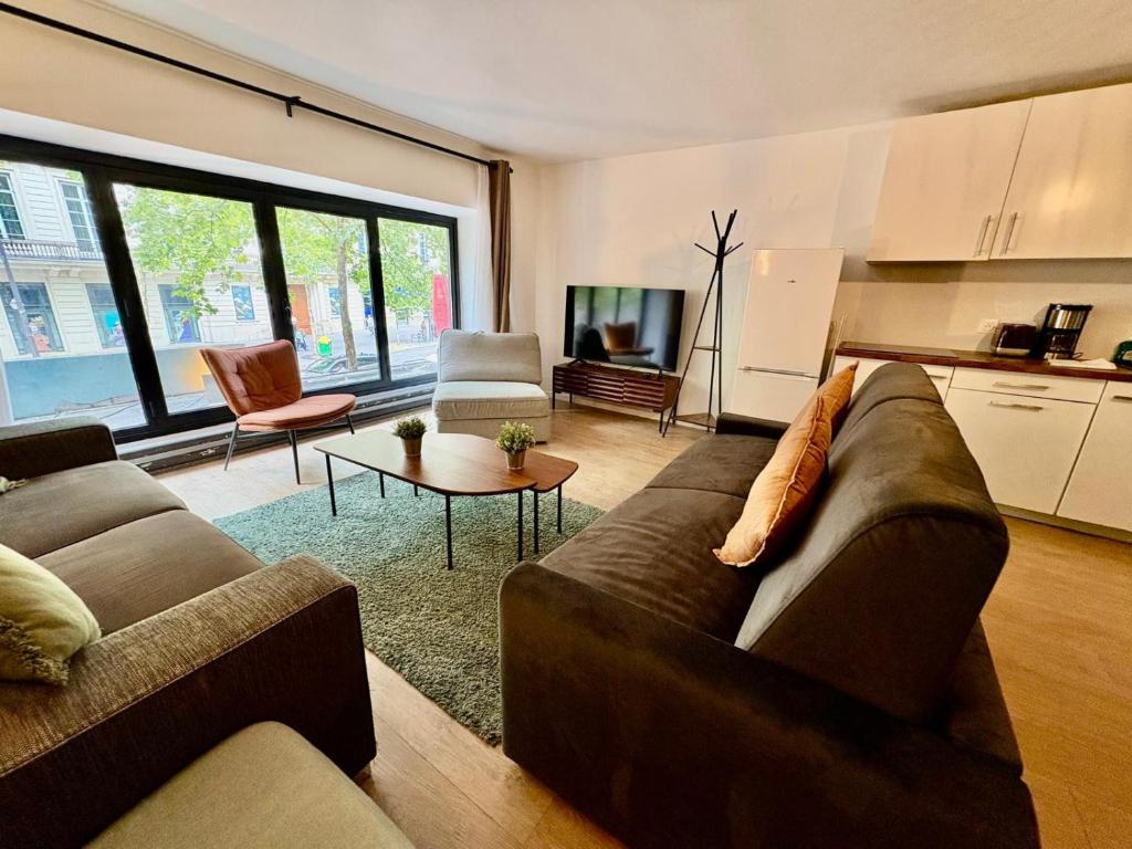 un salon avec un canapé et une table dans l'établissement Urban Flat 194 - Spacious 3 Bedroom Montmartre, à Paris