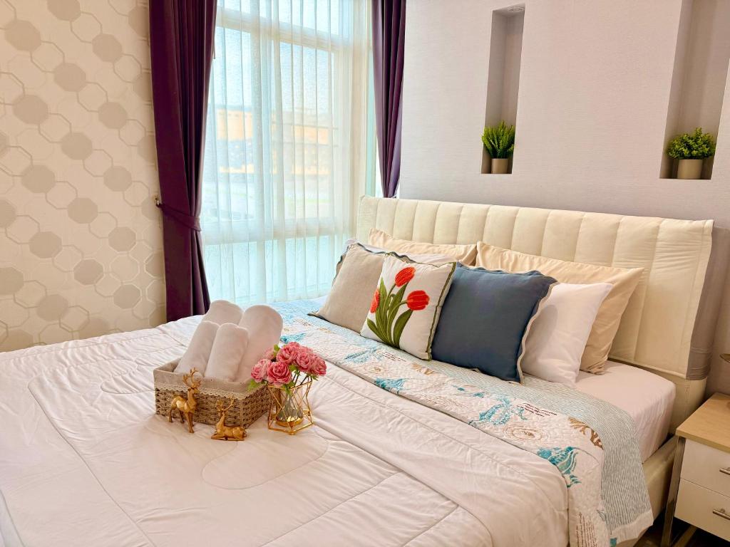 a bedroom with a white bed with flowers on it at My hip Condominium 2 Bedrooms 2 baths comfy room for family in Chiang Mai
