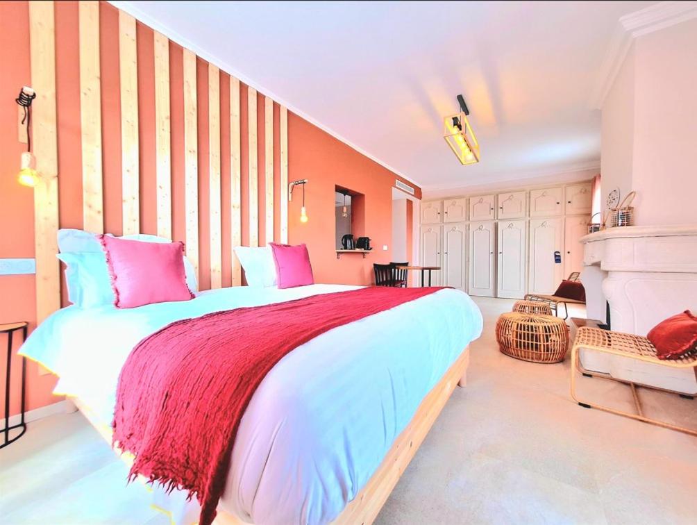 - une chambre dotée d'un grand lit avec des oreillers roses et bleus dans l'établissement Domaine de la Mautanne, à Sainte-Tulle
