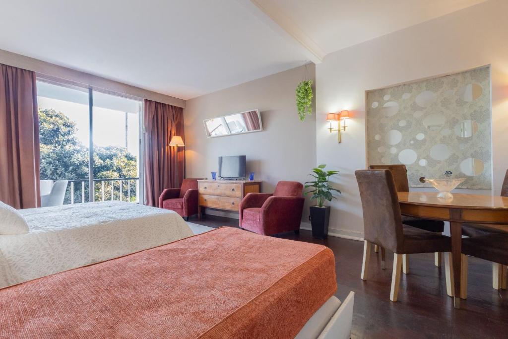 a hotel room with a bed and a table and chairs at Estoril na praia in Estoril