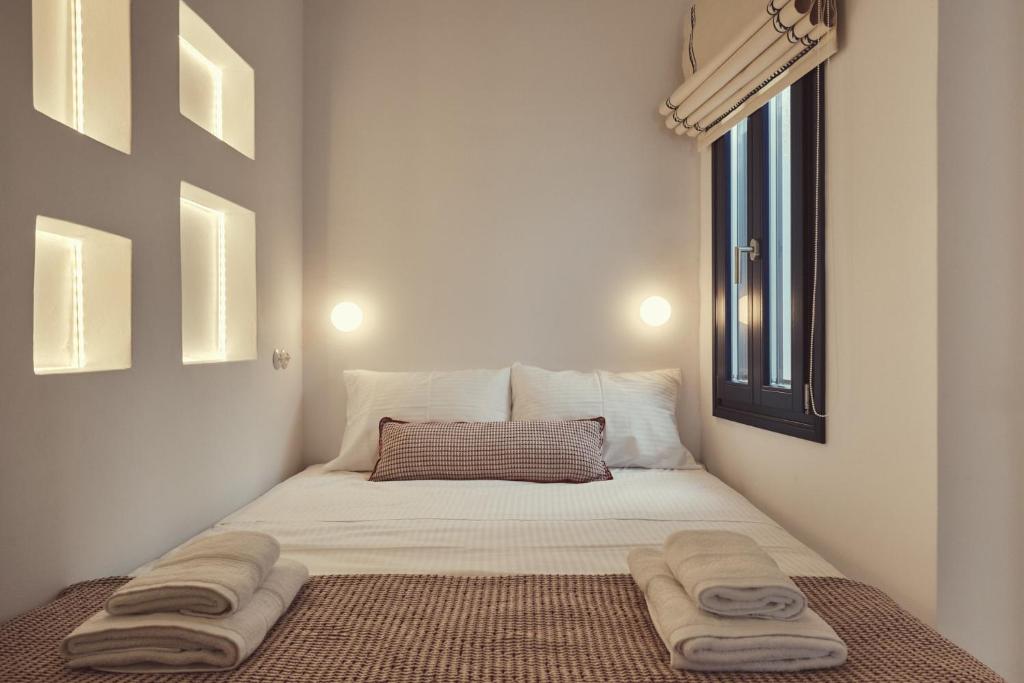 a small bed in a room with towels on it at Retreat Paros, Fisherman's House, The Hook Apartment in Parikia