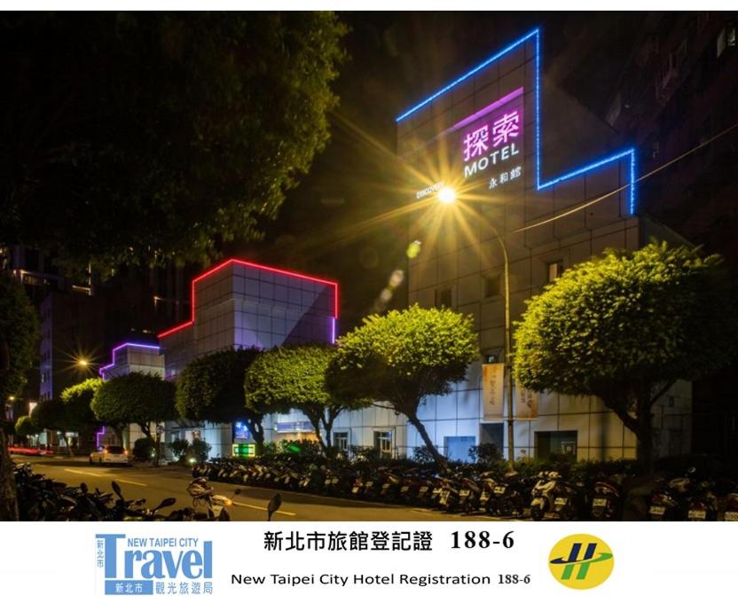 永和探索汽车旅馆-永和分馆的一座前面有霓虹灯的建筑物