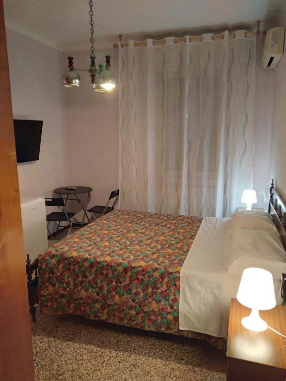 a bedroom with a bed and a table with chairs at Affittacamere di Ilir in Ancona