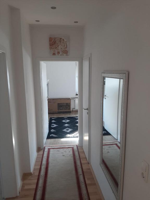 a hallway with a mirror and a hallway with a room at Wohnen auf Zeit HF in Herford