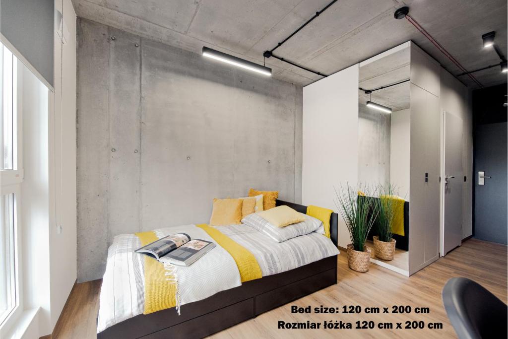 una camera con letto e lenzuola bianche e gialle di SHED Living Kraków a Cracovia