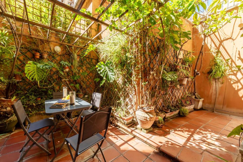 a patio with a table and chairs and plants at Trevi Garden Suite in Rome