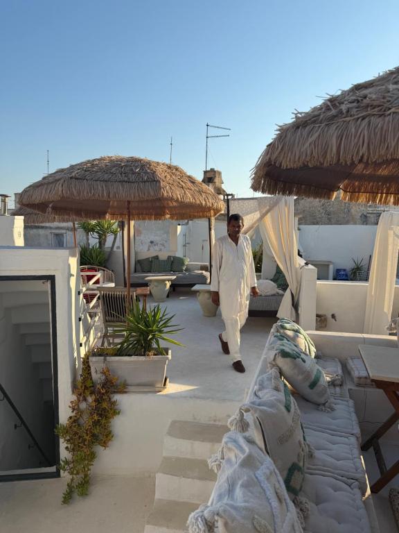 a man walking on a patio next to a couch at Palazzo NUR in Gallipoli