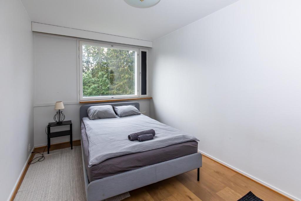 a bedroom with a bed and a window at Spacious one-bedroom apartment near downtown in Lahti