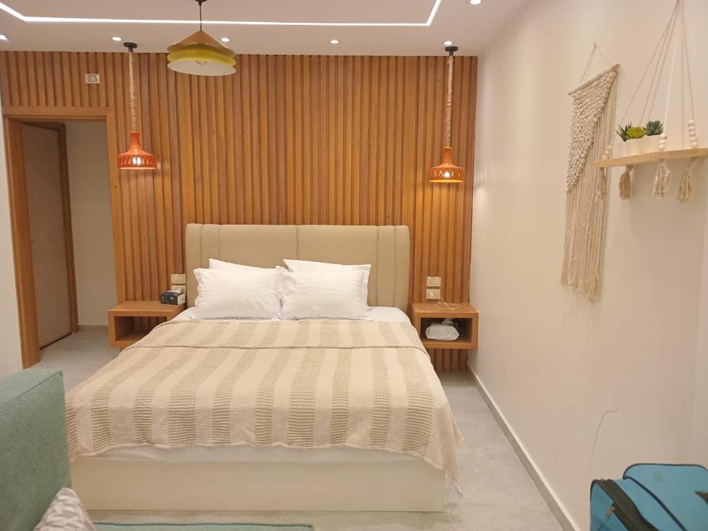 a bedroom with a large bed with two pillows at Jefaira Senior Chalet, 4 bedrooms with roof in Jalāl