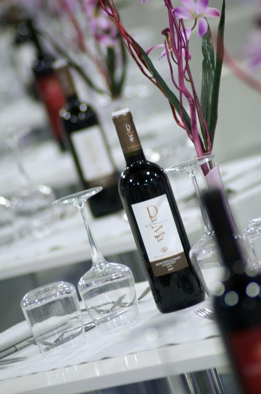 a bottle of wine and glasses on a table at Aurea Hotel in Tortoreto Lido