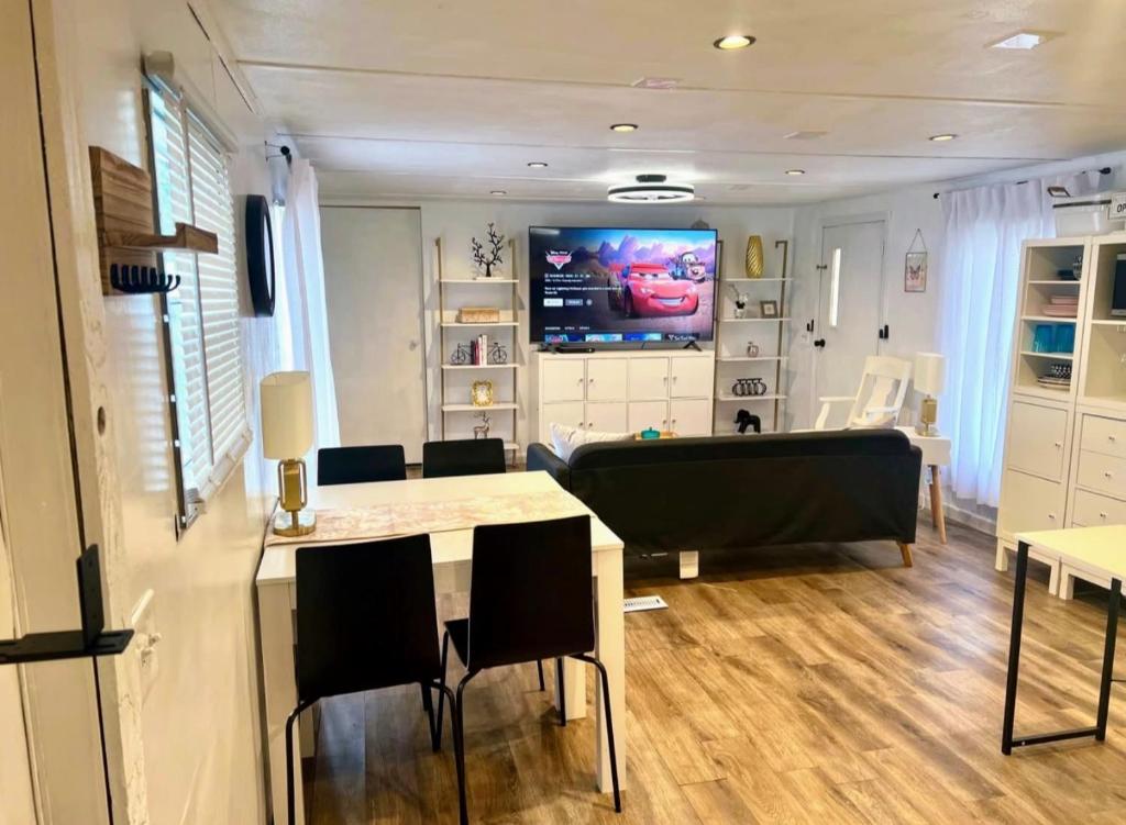een woonkamer met een tv en een tafel en stoelen bij Urban Chic Trailer in Edmond
