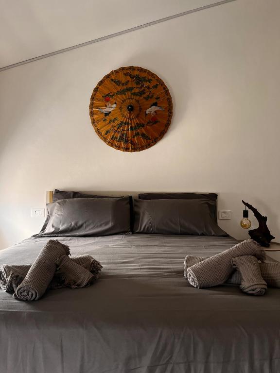 a bedroom with a large bed with a clock on the wall at L'Una Dimora in Certaldo