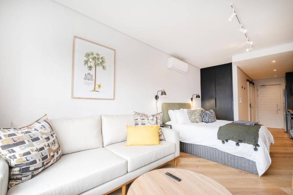 una sala de estar con un sofá y una cama en Paarl Studio 138 - Ultra Modern Apartment with AC and onsite Parking, en Paarl
