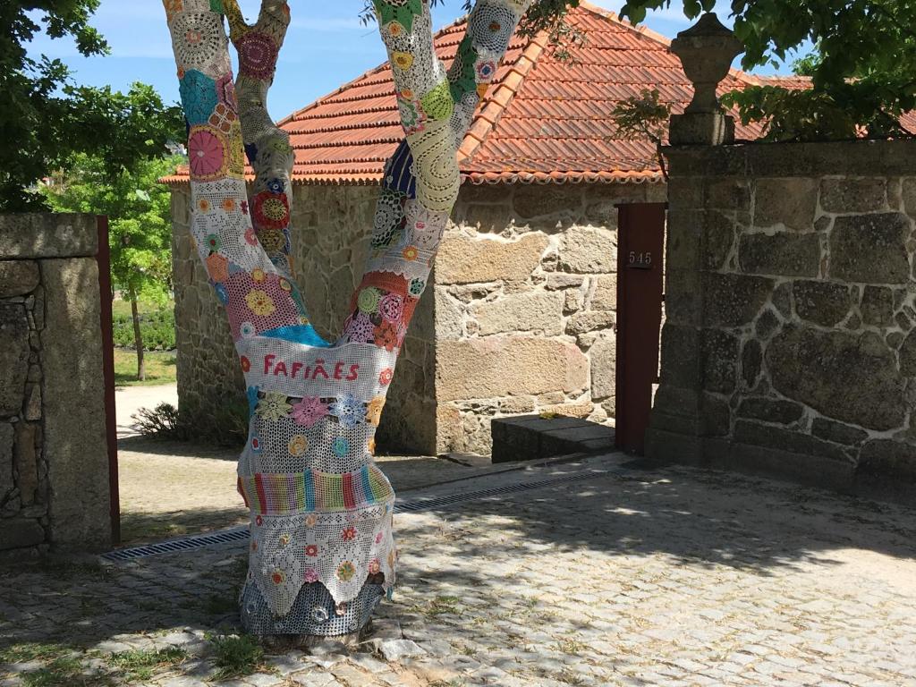 Una estatua de un árbol con un vestido. en Casa da Eira, en Marco de Canaveses