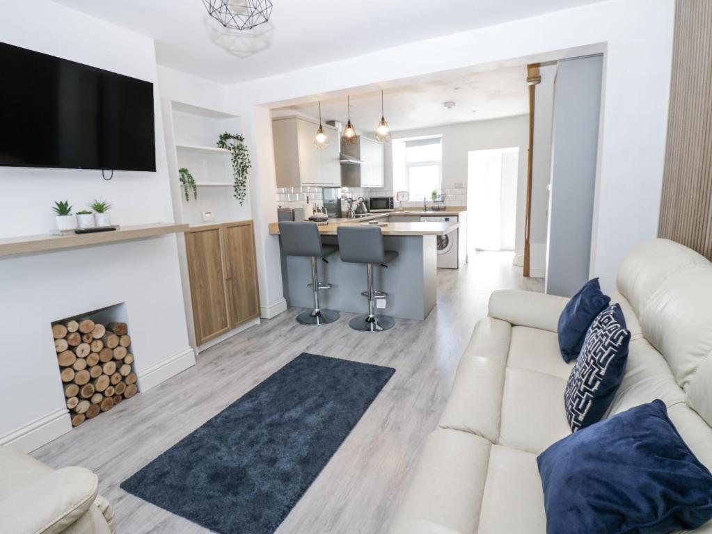 a living room with a white couch and a kitchen at Keekle Terrace in Cleator Moor