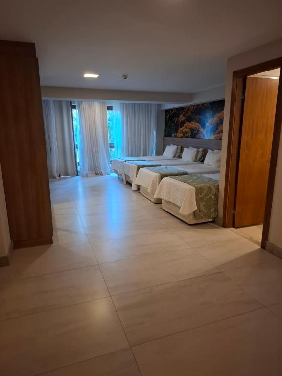 Vista Azul Apart - Vista Mata Atlântica في بيدرا أزول: غرفة نوم بها سريرين ولوحة على الحائط