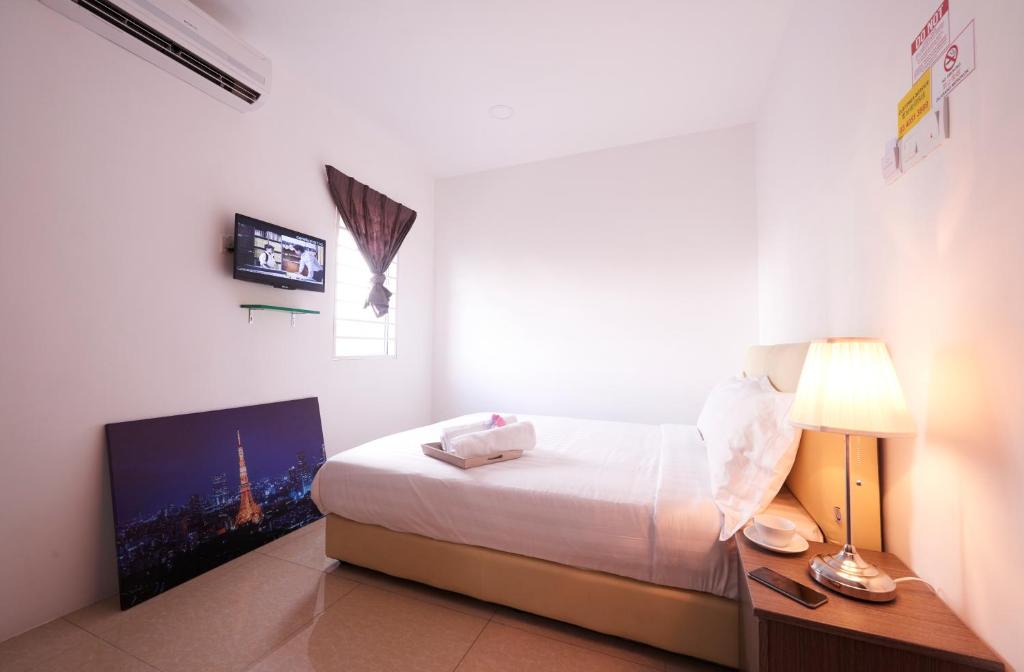 a bedroom with a bed and a desk and a tv at Ipoh Road Hotel in Kuala Lumpur