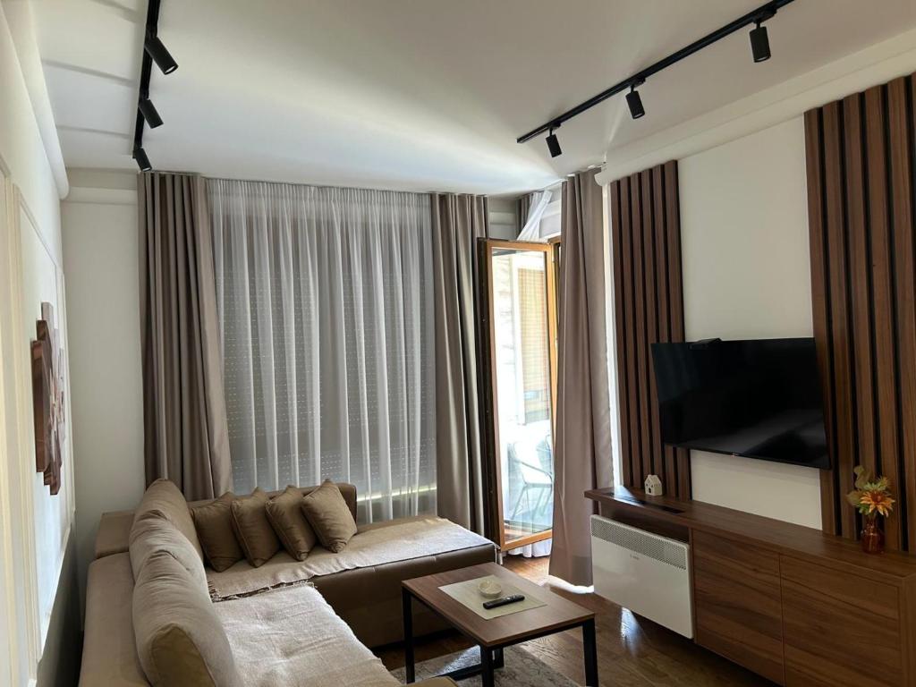 Una sala de estar con un sofá y un televisor de pantalla plana. en Tomi Lux, en Zlatibor
