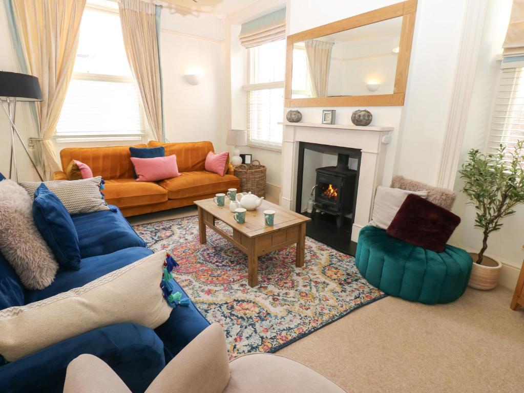 a living room with a couch and a fireplace at Hampton House in St Bees