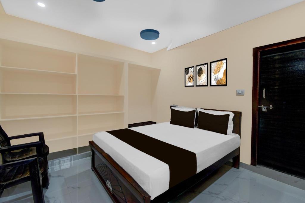 a bedroom with a bed with white and black sheets at Hotel O SR Grand in Bībīnagar